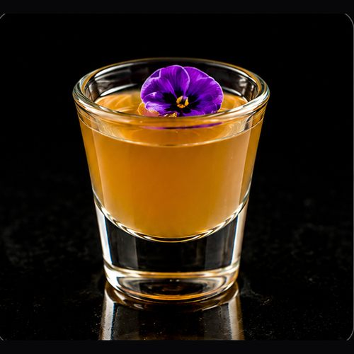 Mai Tai Fighter craft shot with edible flower on a dark bar background